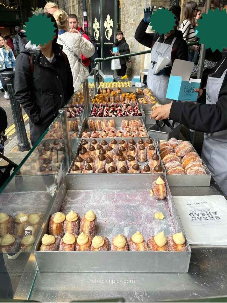 Fresh vanilla cream doughnut from Bread Ahead bakery stall at Borough Market in London.