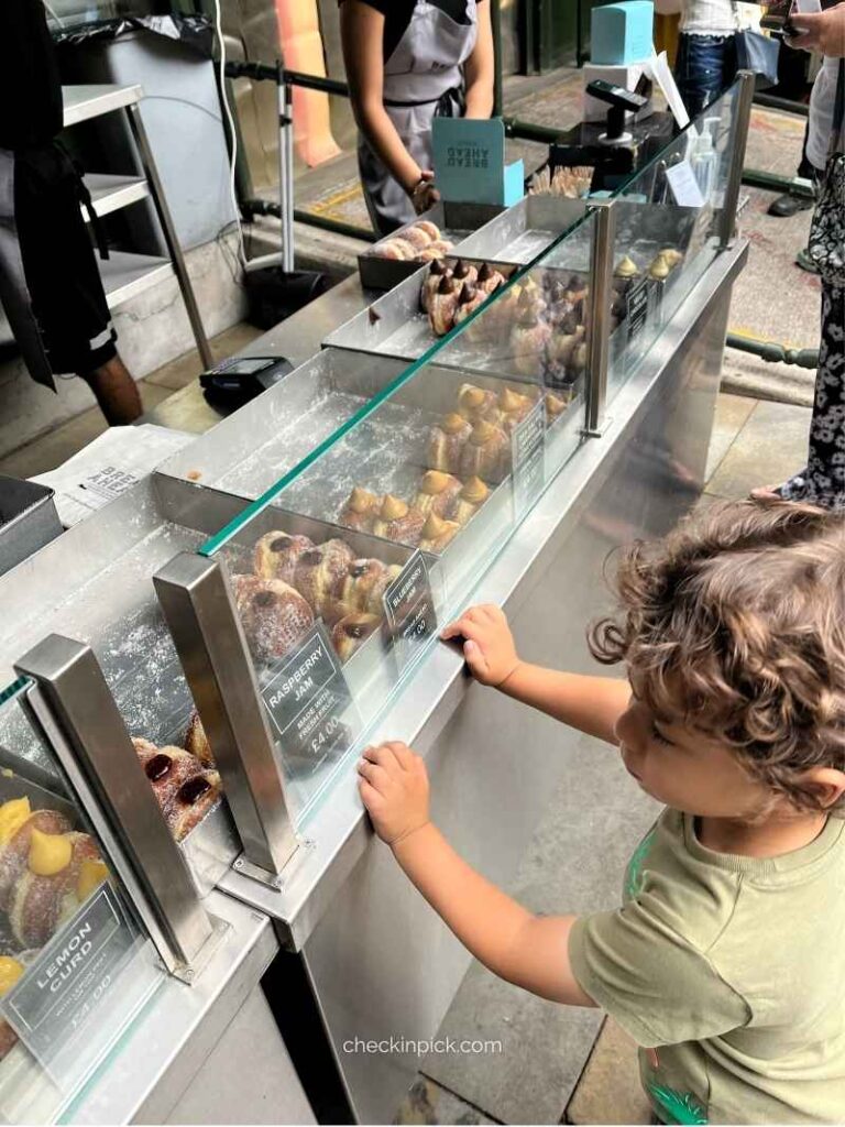 Child waiting for donuts at Borough Market, East London