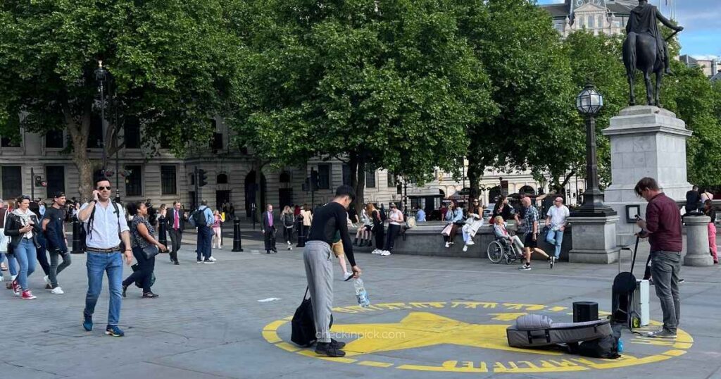 People enjoying street performers at Trafalgar Square, one of the best free things to do in London.