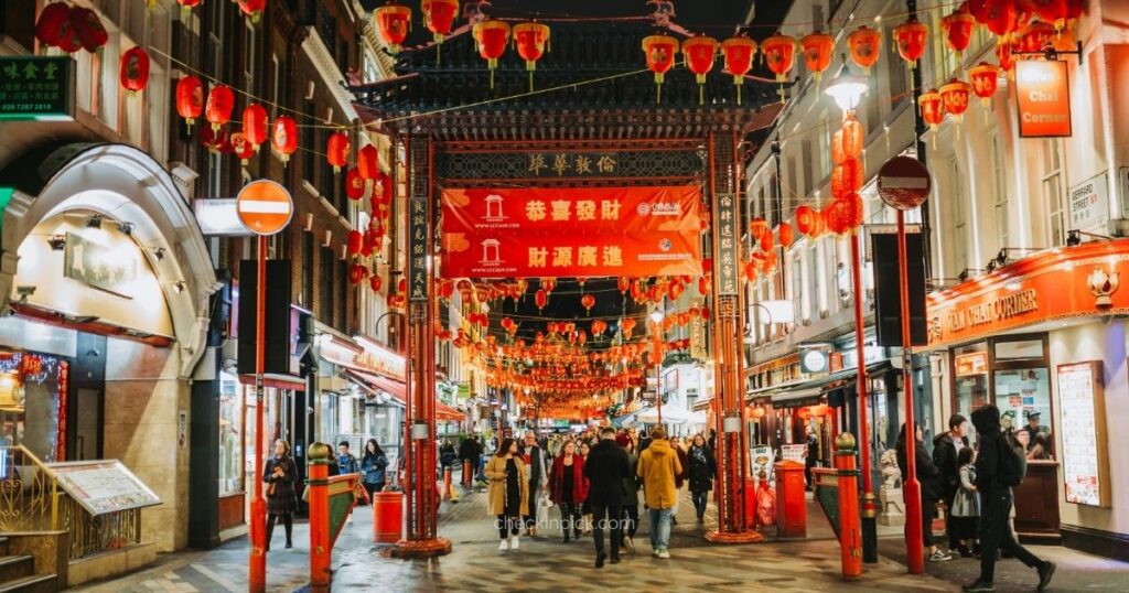 Colorful entrance gate and busy streets in London's Chinatown.