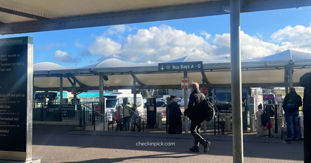 Travelers walking with luggage in front of London Luton Airport main terminal entrance