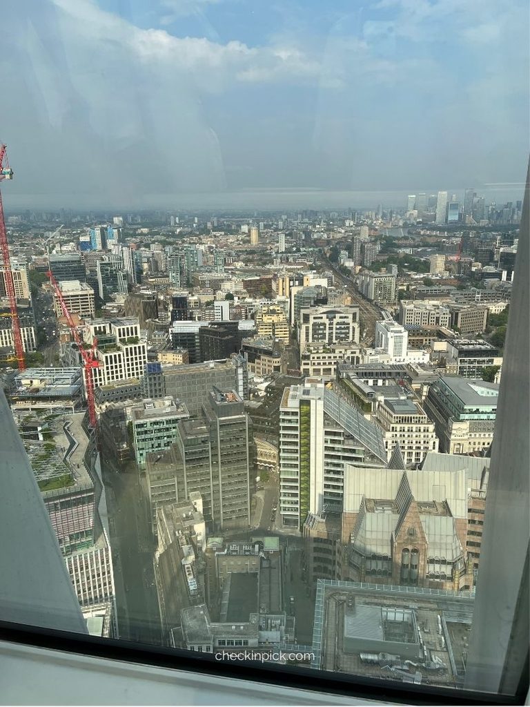 Panoramic view of the London skyline and the River Thames at sunset, viewed through the glass dome of Sky Garden.