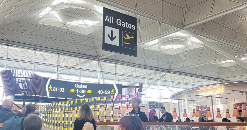 Travelers checking departure information at London Stansted Airport