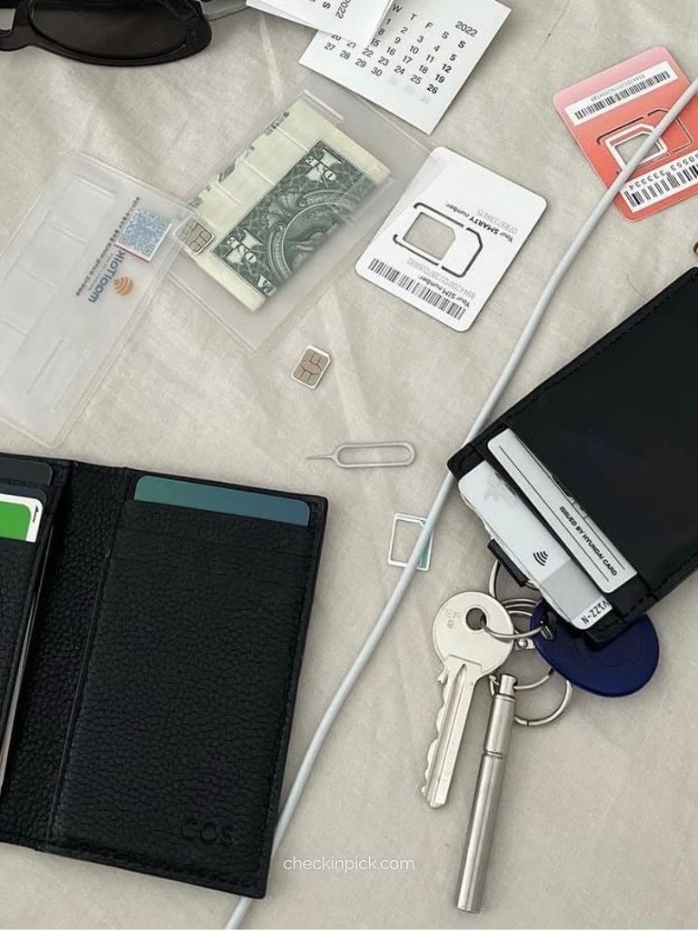 SIM card, SIM ejector tool, and personal items on a black card holder